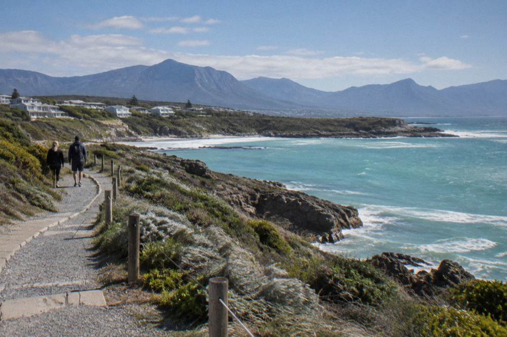 Coastal walking path along a low cliff above a calm bay