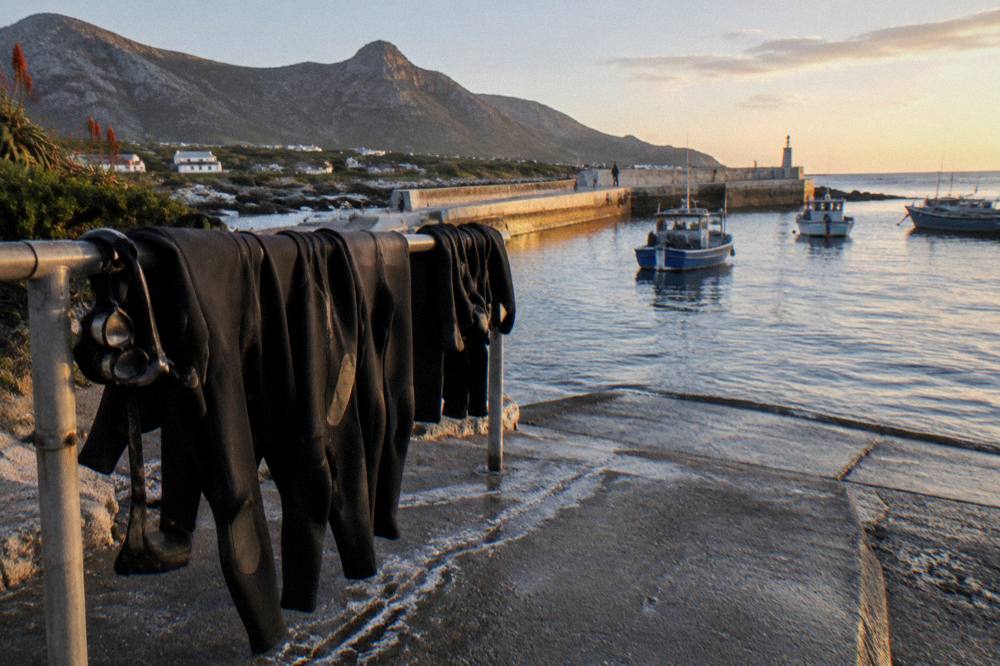 Wetsuits and dive masks hanging to dry beside a harbour slipway